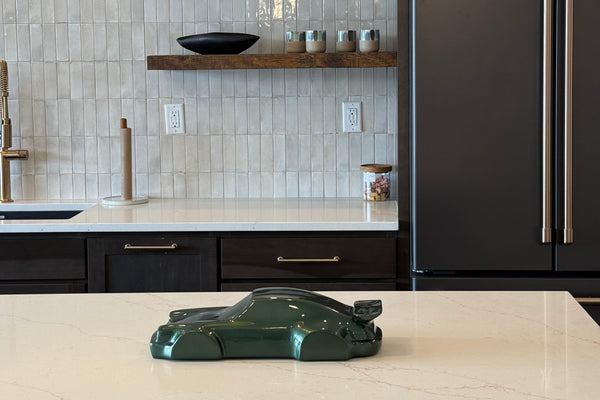Modern kitchen with dark cabinets, tiled backsplash, and decorative wall art.